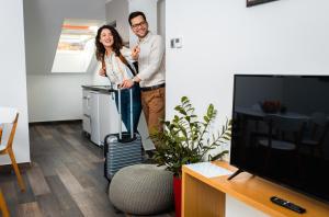 a man and woman standing in an office with a suitcase at Leonardo Loft - Exklusiv, WLAN, Erdgeschoss, 15 Minuten vom Europa Park in Malterdingen