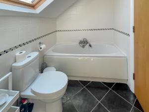 a bathroom with a white tub and a toilet at The Old Laundry 3 in Keswick