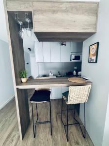 a kitchen with a counter and two stools in a room at Studio 16 Neuquén in Neuquén