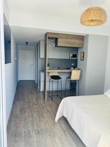 a bedroom with a bed and a kitchen with a table at Studio 16 Neuquén in Neuquén