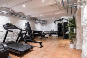 a gym with a treadmill and a elliptical machine at Home Hotel Grand Sundsvall in Sundsvall