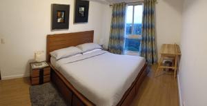 a bedroom with a large bed and a window at Marquee Residences in Angeles +63 photos