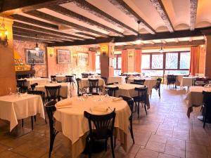 ein Restaurant mit Tischen und Stühlen mit weißen Tischdecken in der Unterkunft Hotel Langa in Cerezo de Abajo