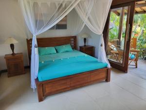 a bedroom with a bed with a canopy at Charming Balinese Holiday Home with private pool in lovina in Lovina +48 photos