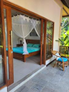 a room with a bed and a chair on a porch at Charming Balinese Holiday Home with private pool in lovina in Lovina