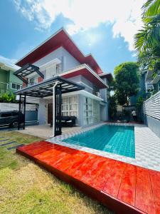 a swimming pool in front of a house at Vibe Phuket Relax in Town in Phuket Town
