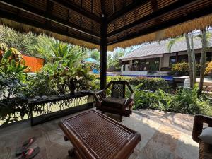 a bench and a chair under a pavilion at Charming Balinese Holiday Home with private pool in lovina in Lovina