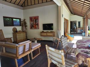 a living room filled with furniture and a flat screen tv at Charming Balinese Holiday Home with private pool in lovina in Lovina