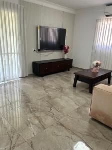 een woonkamer met een flatscreen-tv en een tafel bij גארדן בוטיק צימר בכפר in Mishmar Hashiv‘ah