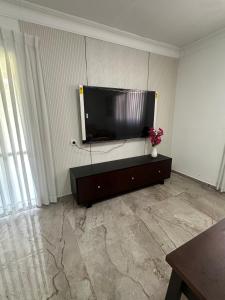 een woonkamer met een flatscreen-tv aan de muur bij גארדן בוטיק צימר בכפר in Mishmar Hashiv‘ah