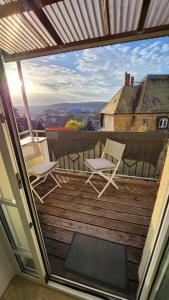 a balcony with chairs and a view of a building at Ruhiger Flussblick vom Balkon in Niederdorla
