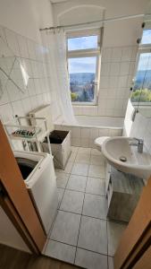 a bathroom with a sink and a toilet and a window at Ruhiger Flussblick vom Balkon in Niederdorla