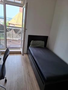 a small bedroom with a bed and a window at Ruhiger Flussblick vom Balkon in Niederdorla