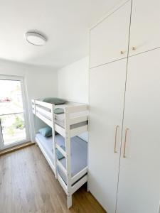 a bedroom with a bunk bed and a white cabinet at Roza in Primošten