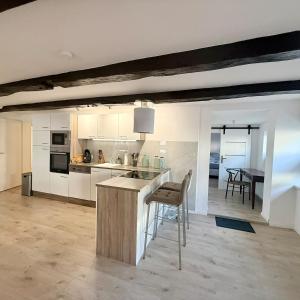 eine Küche mit weißen Schränken und eine Bar mit einem Stuhl in der Unterkunft Ewelina's Fachwerk-Appartment 2 in Sundern