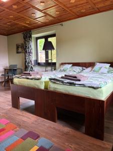 Dolní PodlužíにあるDům Na Výsluníの木製の天井のある部屋にある大きなベッド
