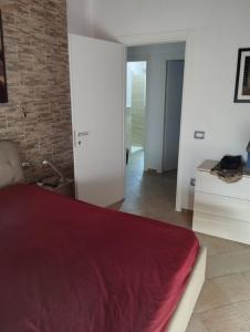 プラーイア・ア・マーレにあるMira Beachの赤いベッドとレンガの壁が備わるベッドルーム1室が備わります。