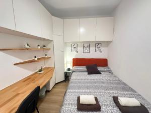 two beds in a small room with white cabinets at Rooms Borrells in Barcelona