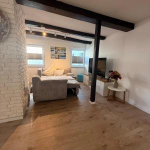 ein Zimmer mit einem Bett, einer Couch und einem Fernseher in der Unterkunft Ewelina's Fachwerk-Appartment 2 in Sundern