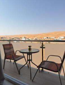 Una mesa y dos sillas en un balcón. en Roma chalet استراحة روما بدية, en Al Raka