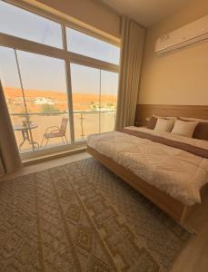 Un dormitorio con una cama y una ventana grande en Roma chalet استراحة روما بدية, en Al Raka