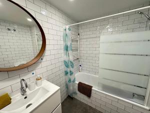 a bathroom with a sink and a mirror and a tub at Rooms Borrells in Barcelona