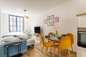 a room with a table and chairs and a bed at L'Escapade Médiévale Appartement neuf in Josselin