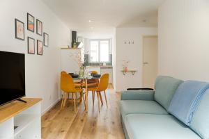 a living room with a blue couch and a table at L'Escapade Médiévale Appartement neuf in Josselin