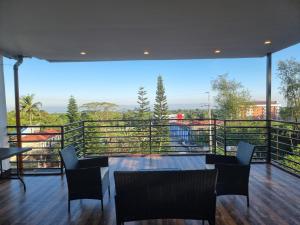 SungayTwin Sister House Tagaytay Private Pool的阳台上有桌子和椅子的房间