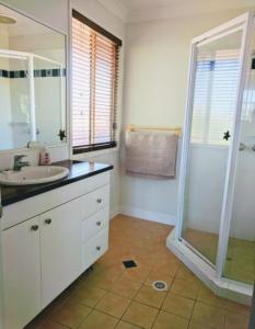a white bathroom with a sink and a shower at Terrace River House in Caddys Island