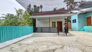 a house with a gate and a blue fence at VAL Homestay in Siquijor