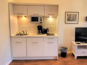 a kitchen with a sink and a microwave at Hotel Hubertusburg in Kühlungsborn
