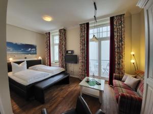 a hotel room with a bed and a couch at Hotel Hubertusburg in Kühlungsborn +56 photos