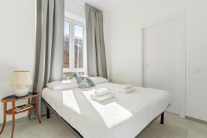 a white bed in a room with a window at Baroni C - FREE private parking-wi- fi and A-C in Gerenzano