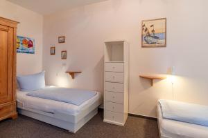 1 dormitorio pequeño con 2 camas y armario en Haus Uthlande Uthlande Whg 23 Lütte Bris, en Wyk auf Föhr 29 fotos más