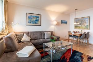 una sala de estar con un sofá y una mesa en Haus Uthlande Uthlande Whg 23 Lütte Bris, en Wyk auf Föhr