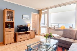 Una sala de estar con un sofá y un televisor. en Haus Uthlande Uthlande Whg 23 Lütte Bris, en Wyk auf Föhr