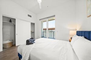 ein weißes Schlafzimmer mit einem großen Bett und einer Badewanne in der Unterkunft Cozy Beachside Escape with Great Views in Long Beach + 18 Fotos