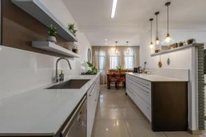 a kitchen with white countertops and a dining room at Perfect Family Vacation-Private Pool Eilat in Eilat