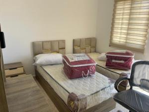 two beds with bags on them in a room at 2 Bedroom apartment in Jerash Centre in Jerash