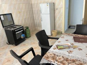 a kitchen with a table and a stove and a refrigerator at 2 Bedroom apartment in Jerash Centre in Jerash