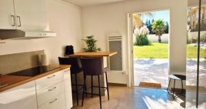 a kitchen with a counter and stools in it at Appartement Carpe diem in Orange