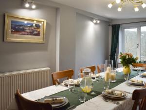 a dining room with a table with a green table cloth at Tigh Raineach in Strathyre