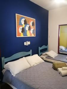 a bedroom with two beds and a blue wall at Pousada Estrada Real in Paraty +37 photos