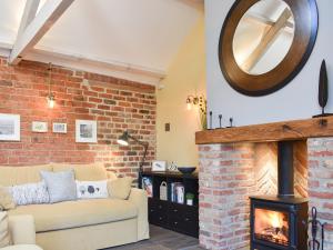 ein Wohnzimmer mit Couch und Kamin in der Unterkunft Primrose in Scruton