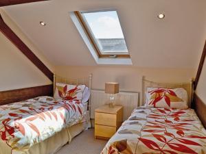 two beds in a bedroom with a skylight at Fenn House in Alvechurch