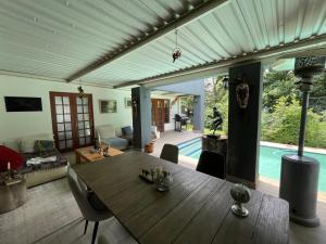 een woonkamer met een houten tafel en een zwembad bij The Little Mongrel Deluxe Space Bryanston in Johannesburg