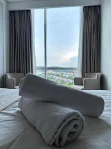 a towel laying on a bed in a hotel room at Panbil Residence Apartment Lvl 15 with Forest View in Kangboi