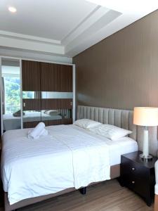 a bedroom with a large white bed and a mirror at Panbil Residence Apartment Lvl 15 with Forest View in Kangboi