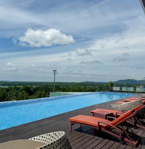 a large swimming pool with lounge chairs on a deck at Panbil Residence Apartment Lvl 15 with Forest View in Kangboi